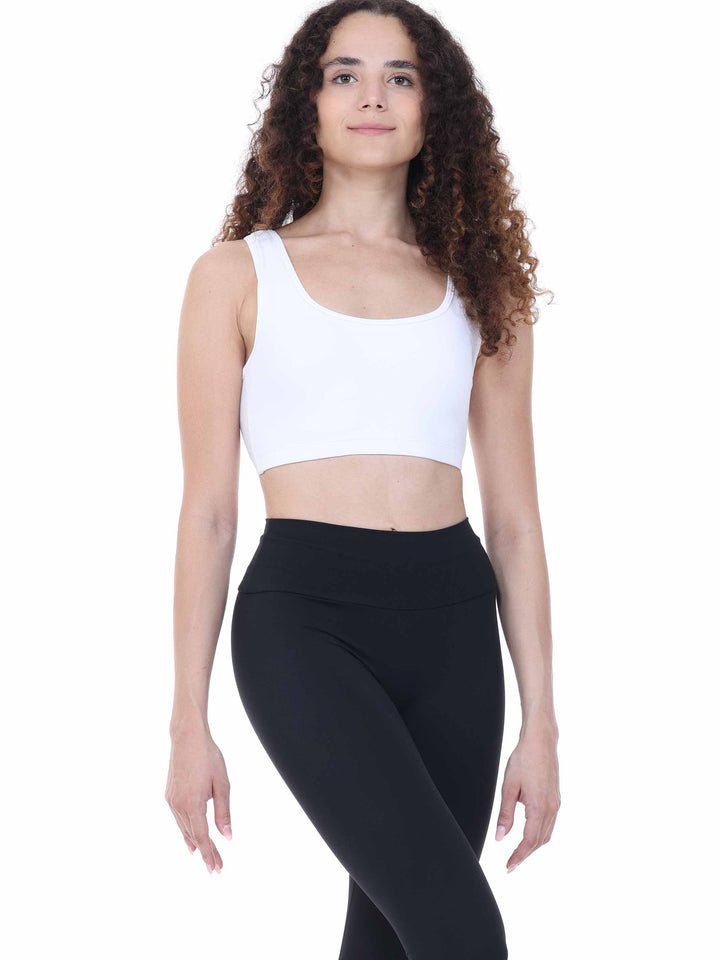 Profil d’une danseuse portant un top brassière blanc – style minimaliste et fonctionnel pour la pratique.