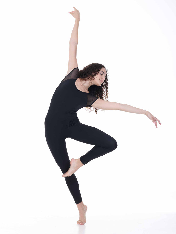 Danseuse portant la combinaison de danse Sway – modèle Sheer Cap Sleeve Dance Unitard en noir, exécutant une pose de danse moderne avec un bras levé, sur fond blanc.