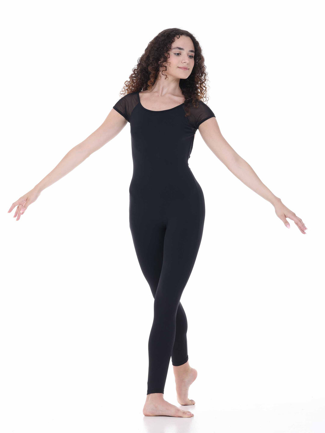 Danseuse portant la combinaison Sway – modèle Sheer Cap Sleeve Dance Unitard en noir, adoptant une posture fluide avec les bras ouverts, sur fond blanc.