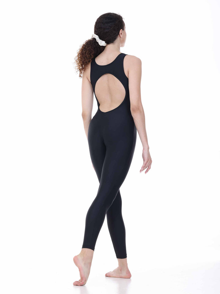 Danseuse vue de dos portant un justaucorps intégral noir à dos rond ajouré, en position de marche gracieuse sur fond blanc.