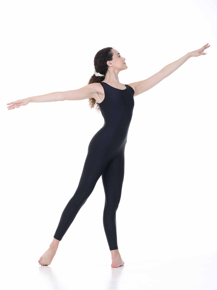 Danseuse portant le justaucorps intégral Sway – modèle Circular Back Tank Dance Unitard en noir, exécutant une pose de danse classique avec les bras levés, sur fond blanc.