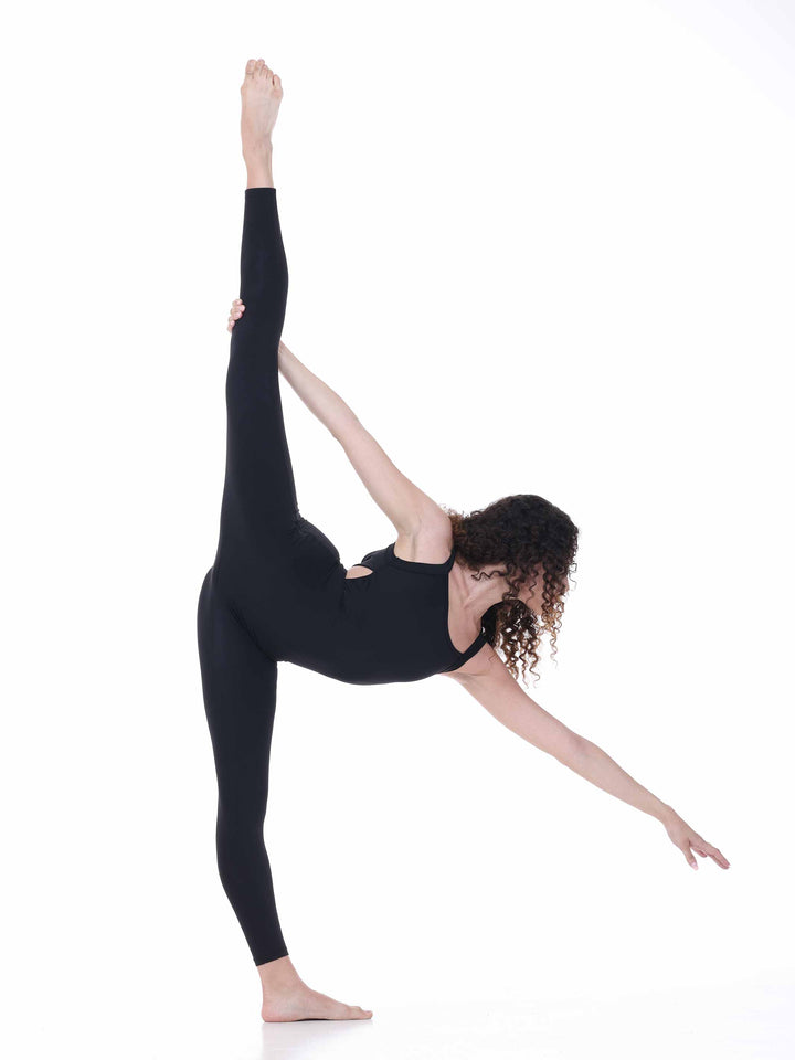 Danseuse en unitard noir effectuant une extension de jambe – tenue souple pour danse moderne ou yoga.