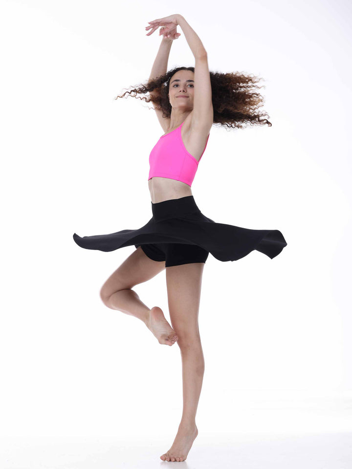 Danseuse en mouvement portant une jupe de danse fluide noire avec short intégré – tenue Freedom Flow pour répétition.