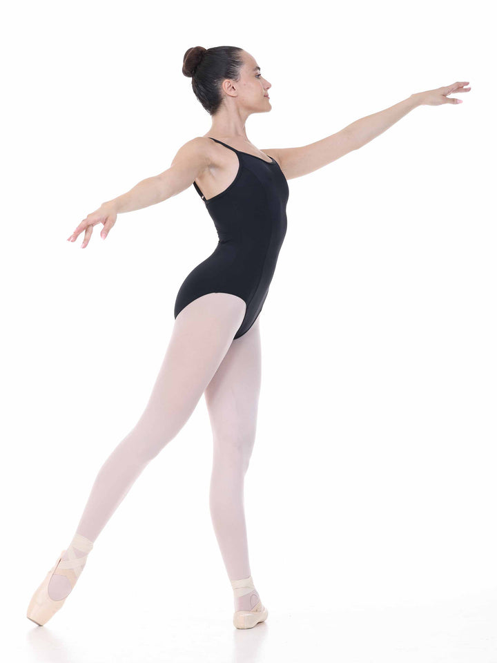 Profil de danseuse en mouvement portant un justaucorps noir à coutures avant – tenue souple pour studio de danse.