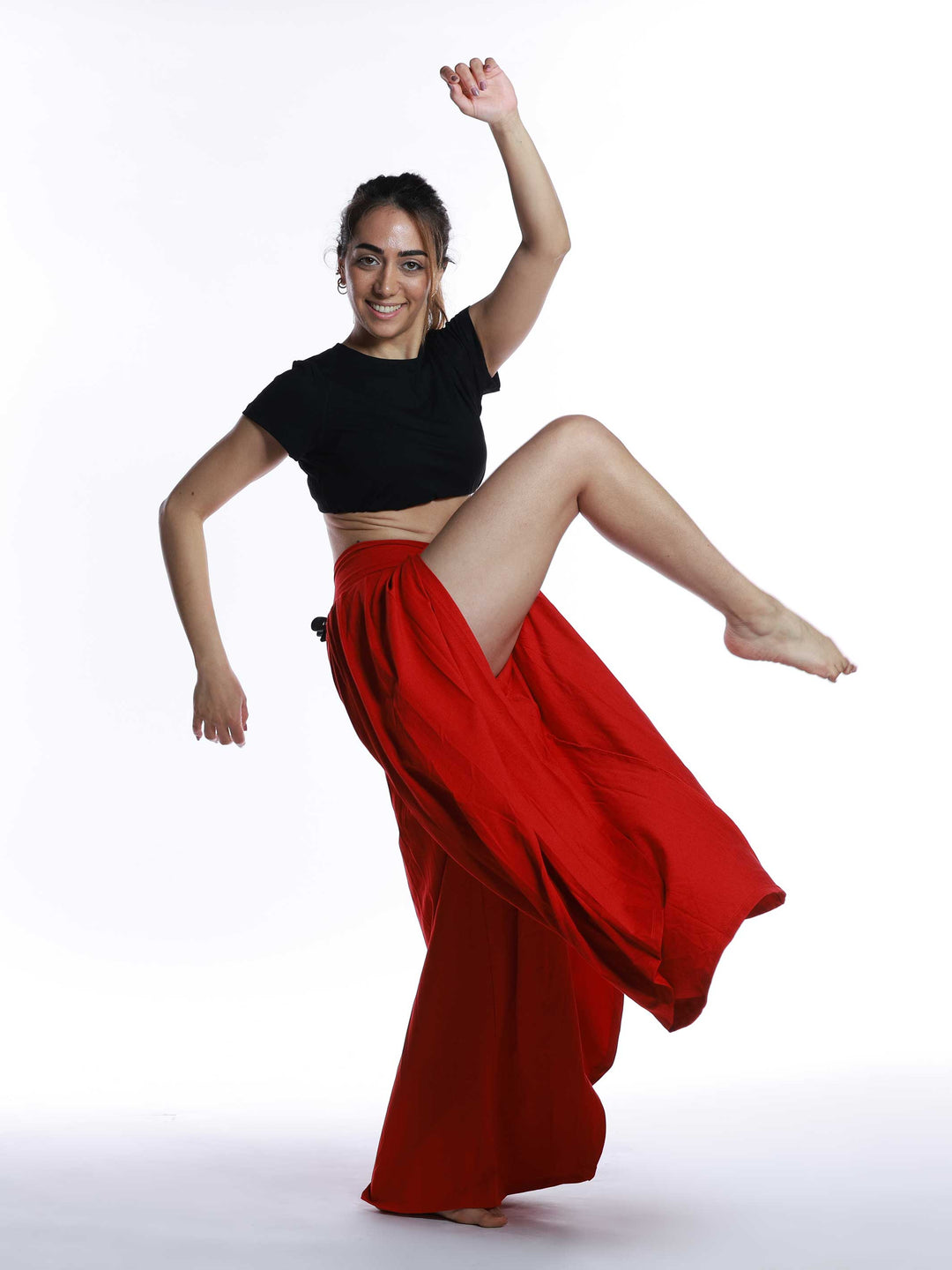 Danseuse en plein saut portant un pantalon Freeform rouge – tenue dynamique pour danse jazz.