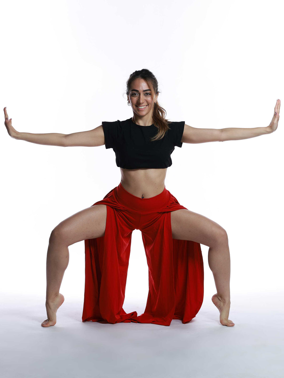 Danseuse en mouvement avec pantalon de danse rouge – look expressif et ample.