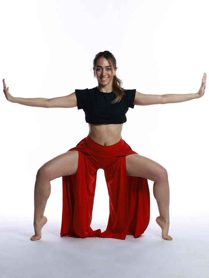 Danseuse en mouvement avec pantalon de danse rouge – look expressif et ample.
