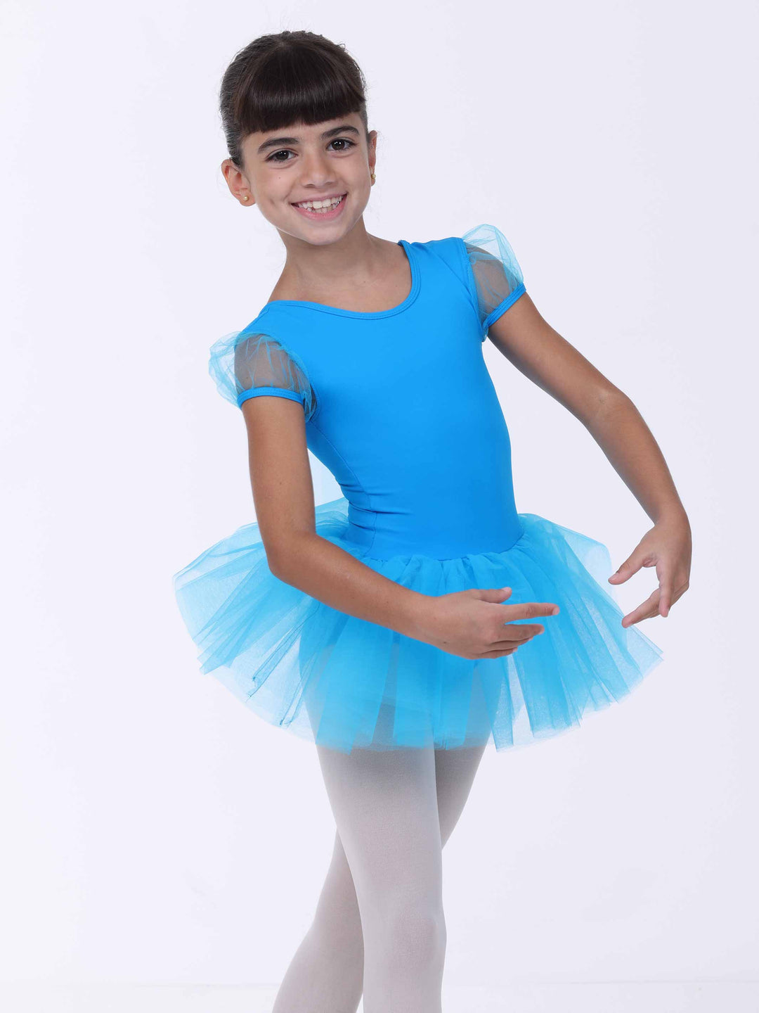 Jeune danseuse souriante en robe de danse bleu clair – manches transparentes et jupe évasée.