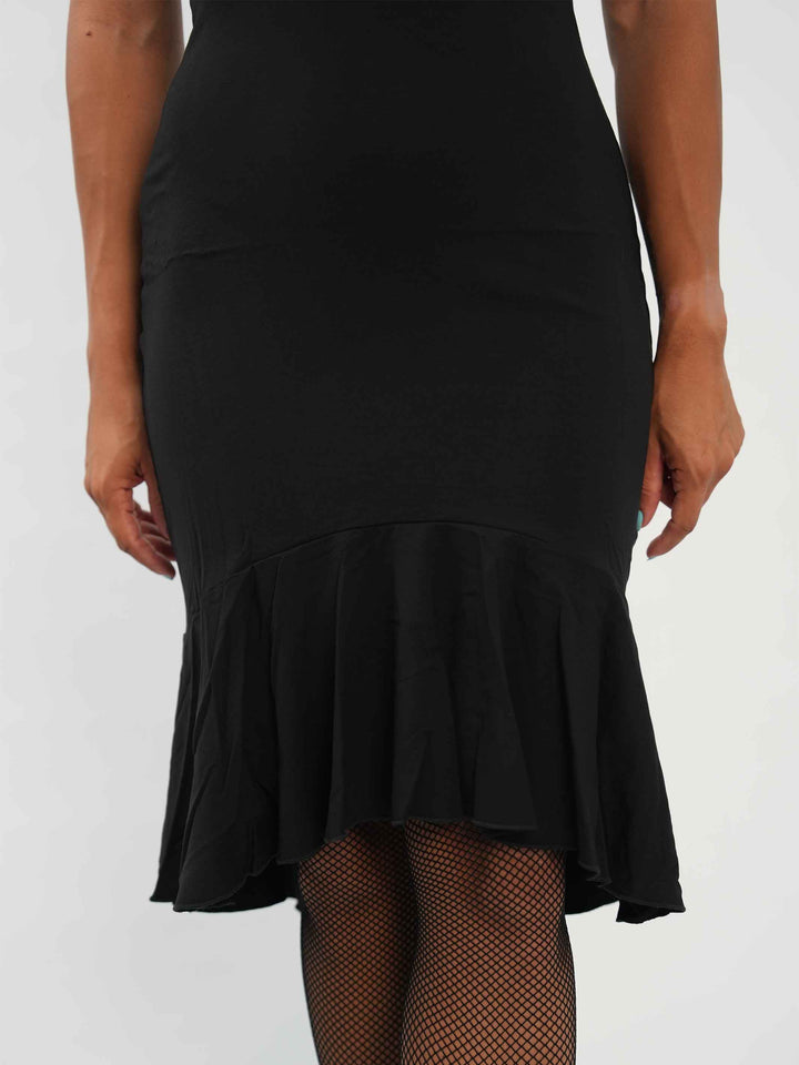 Femme portant une élégante robe latine noire asymétrique avec une manche volante, jupe fluide à godets, idéale pour la salsa, la bachata ou autres danses latines. vue de la jupe