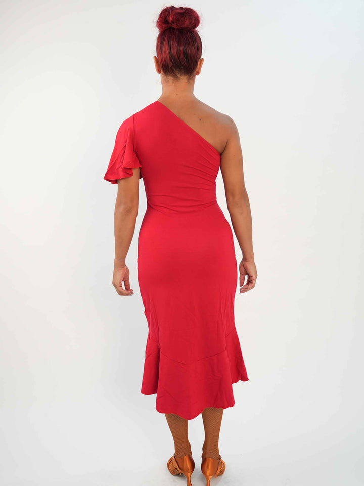 Femme portant une élégante robe latine rouge asymétrique avec une manche volante, jupe fluide à godets, idéale pour la salsa, la bachata ou autres danses latines. vue arrière