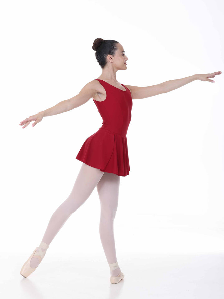 Danseuse en mouvement portant une robe bordeaux de danse classique – ligne élégante et silhouette élancée.