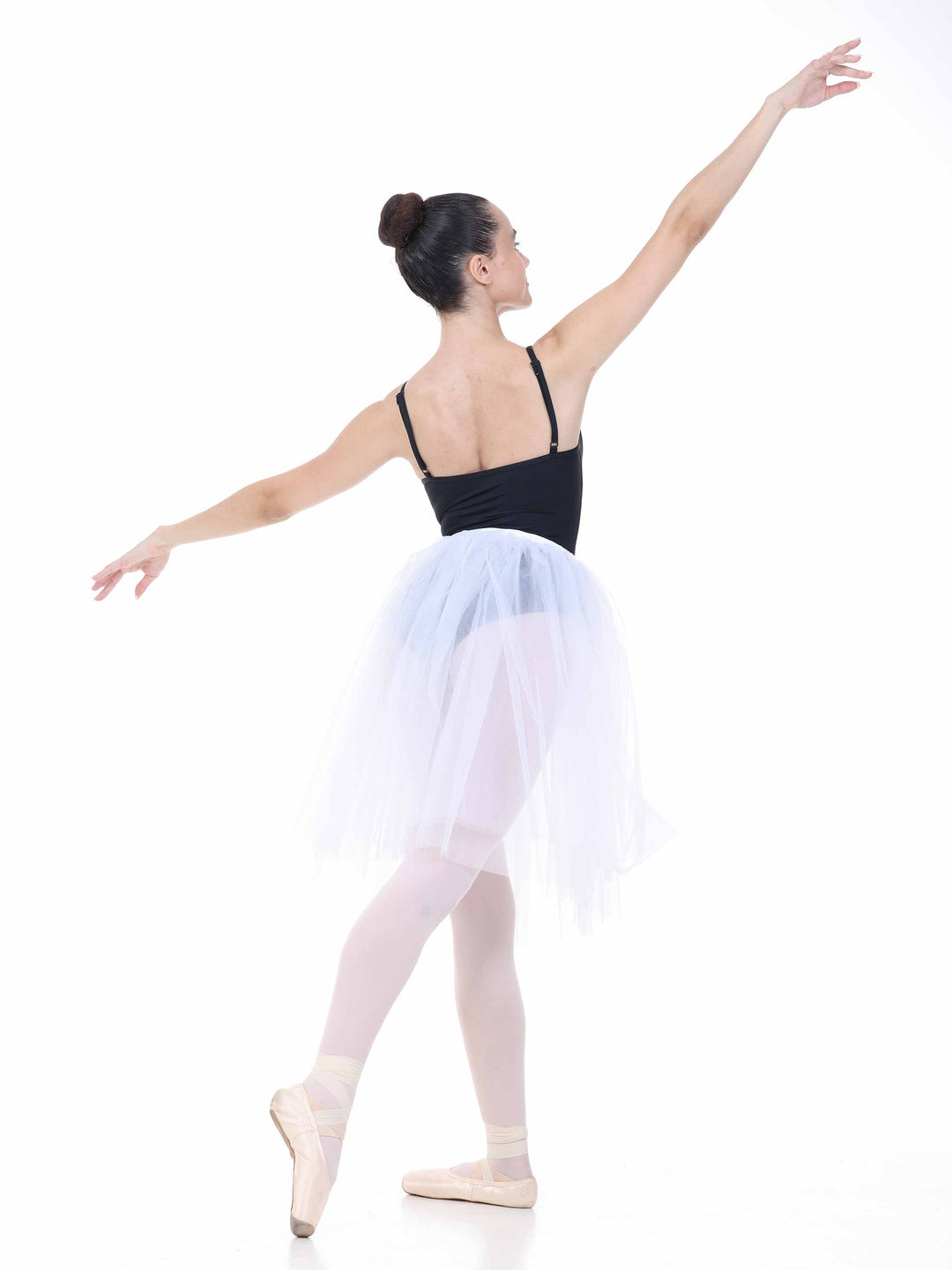 Ballerine en tutu blanc mi-long – mouvement gracieux et silhouette de danse classique.
