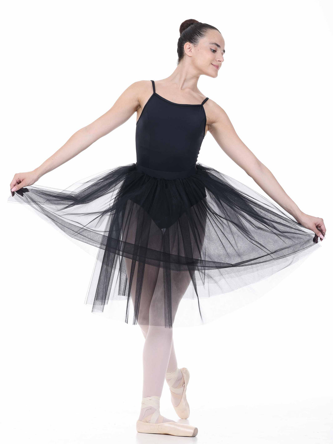 Danseuse classique en tutu noir en tulle, posant dans une position de ballet – look romantique.